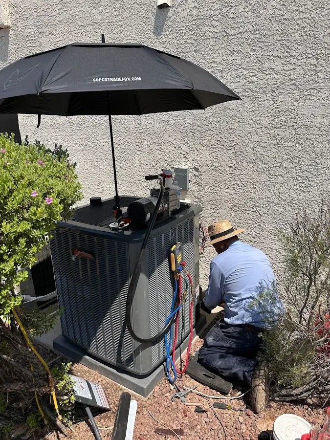 HVAC technician performing outdoor AC maintenance in Upper Deerfield