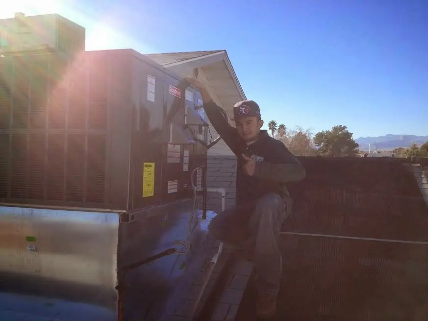HVAC technician performing Air Duct Cleaning on a rooftop unit in Upper Deerfield